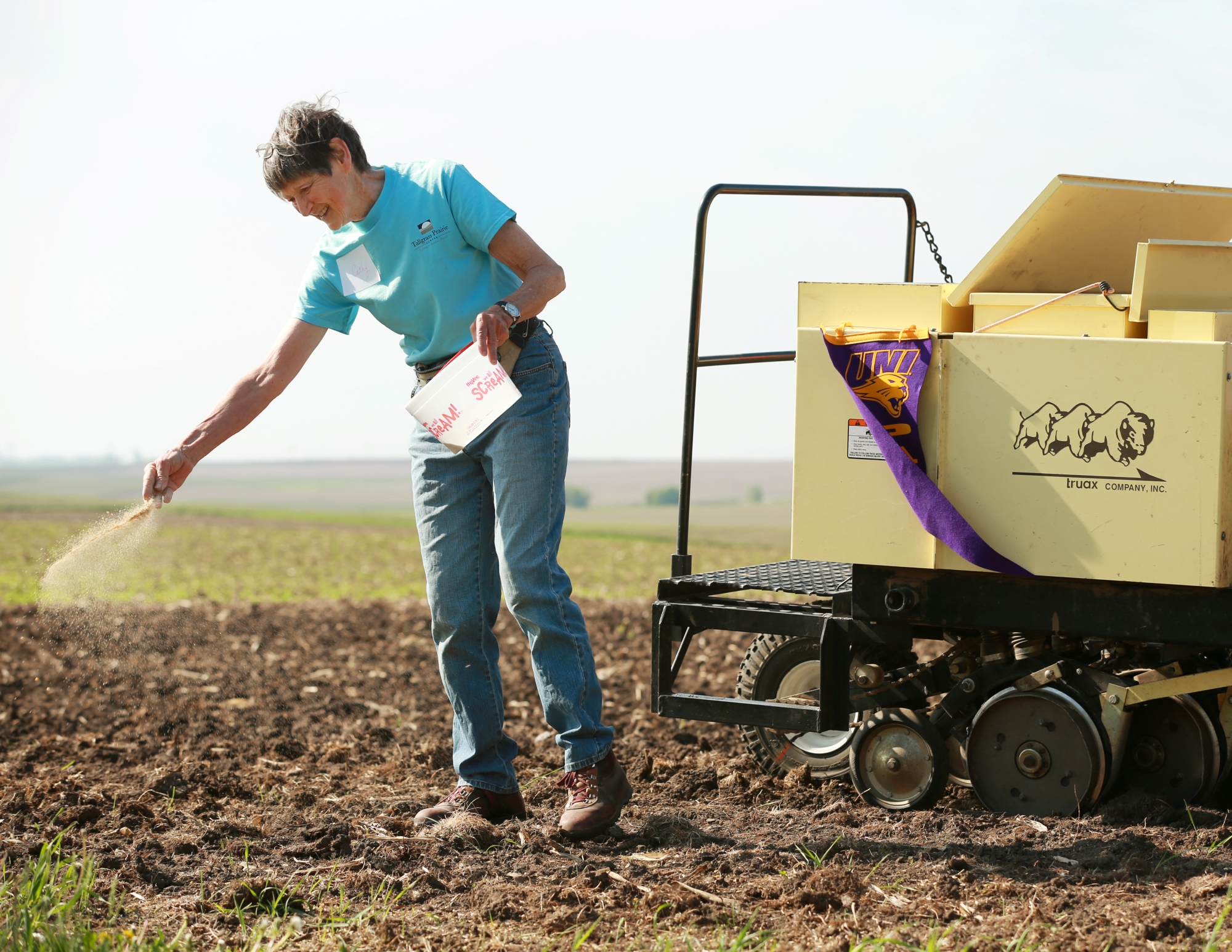 Cathy Irvine spreading prairie seed at Irvine Prairie